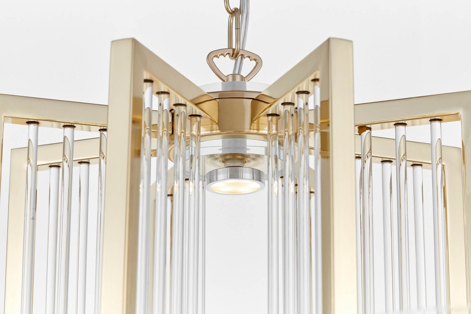 Zbliżenie na detale geometrycznej ramy złotej lampy wiszącej MANHATTAN W8 z transparentnymi rurkami