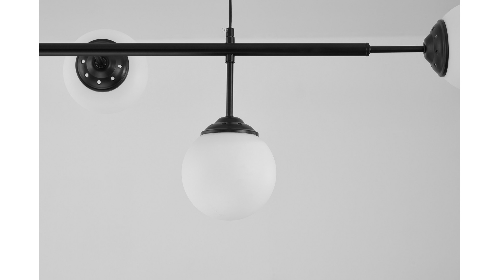 Zbliżenie na czarny stelaż lampy z okrągłym, matowym kloszem w stylu modern loft.