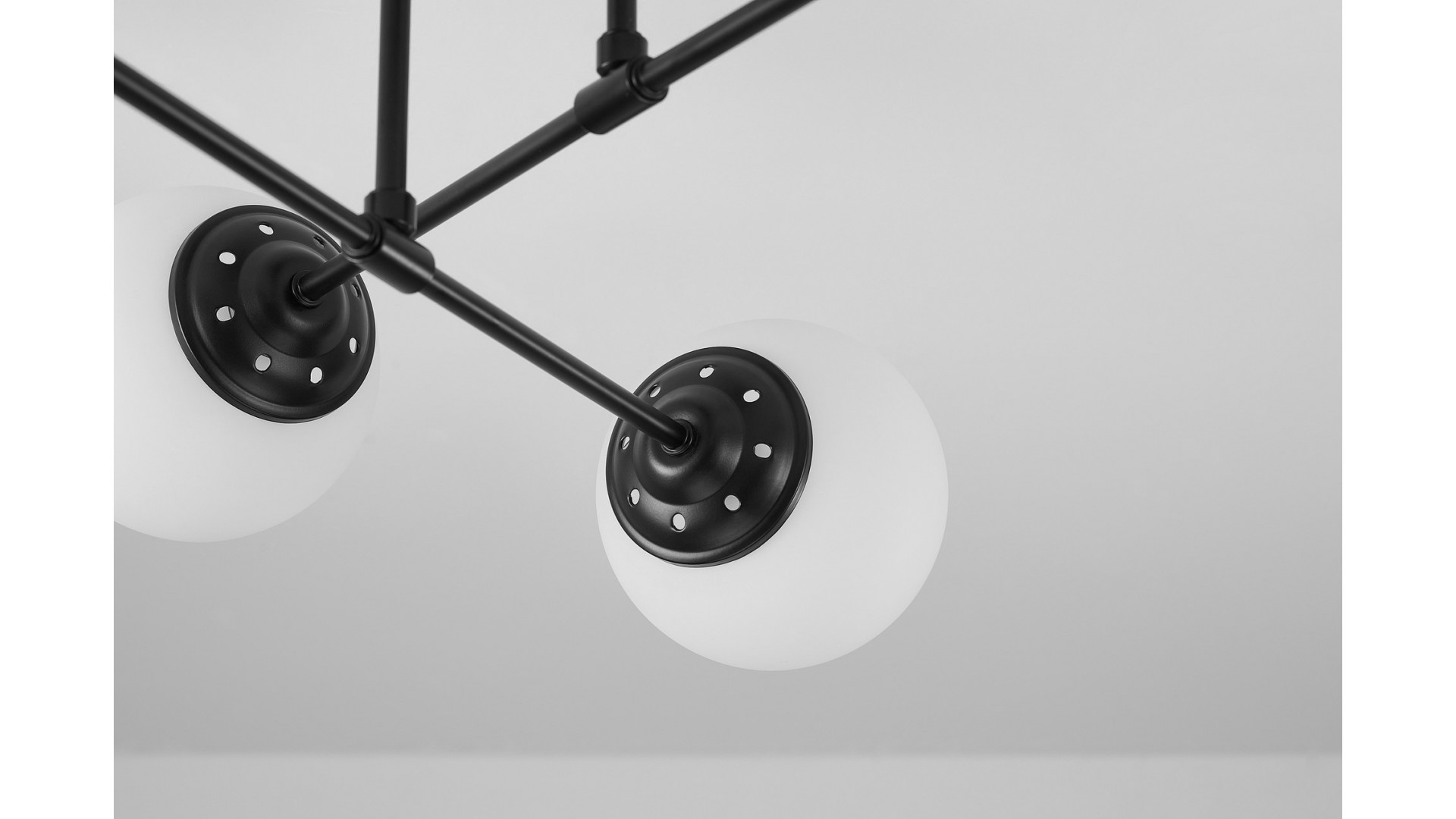 Lampa wisząca producent Lampit model Fino z białymi kulistymi kloszami na czarnych ramionach w nowoczesnym stylu