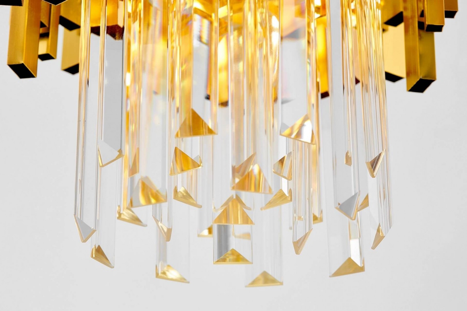 Detale złotej lampy z kryształowymi elementami – elegancki design z geometrycznymi akcentami.