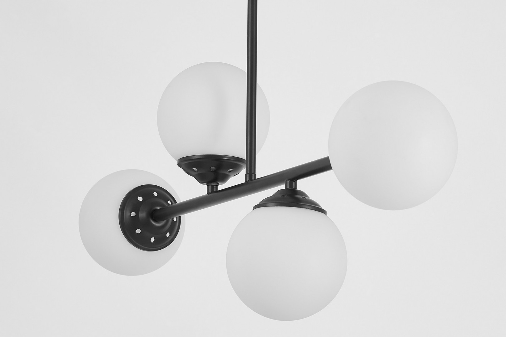 Zbliżenie na czarną lampę z kloszami w kształcie kul, eleganckie mocowanie z otworami, subtelny design.