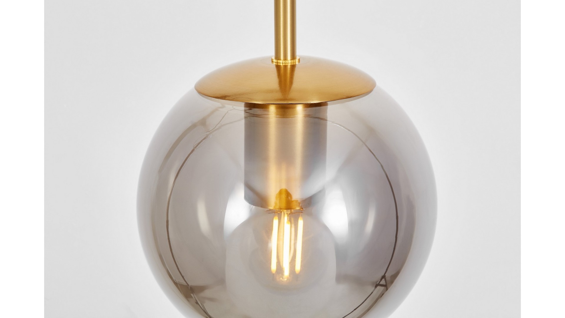 Zbliżenie na złoty szczotkowany element lampy ZODIAK Lumina Deco ze szklanym kloszem