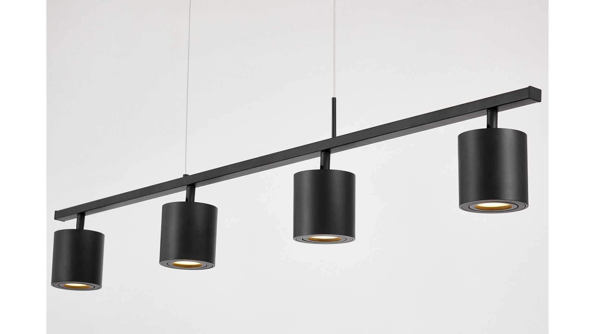 Czarna lampa wisząca z czterema cylindrycznymi spotami LED na długiej listwie, nowoczesne oświetlenie sufitowe.