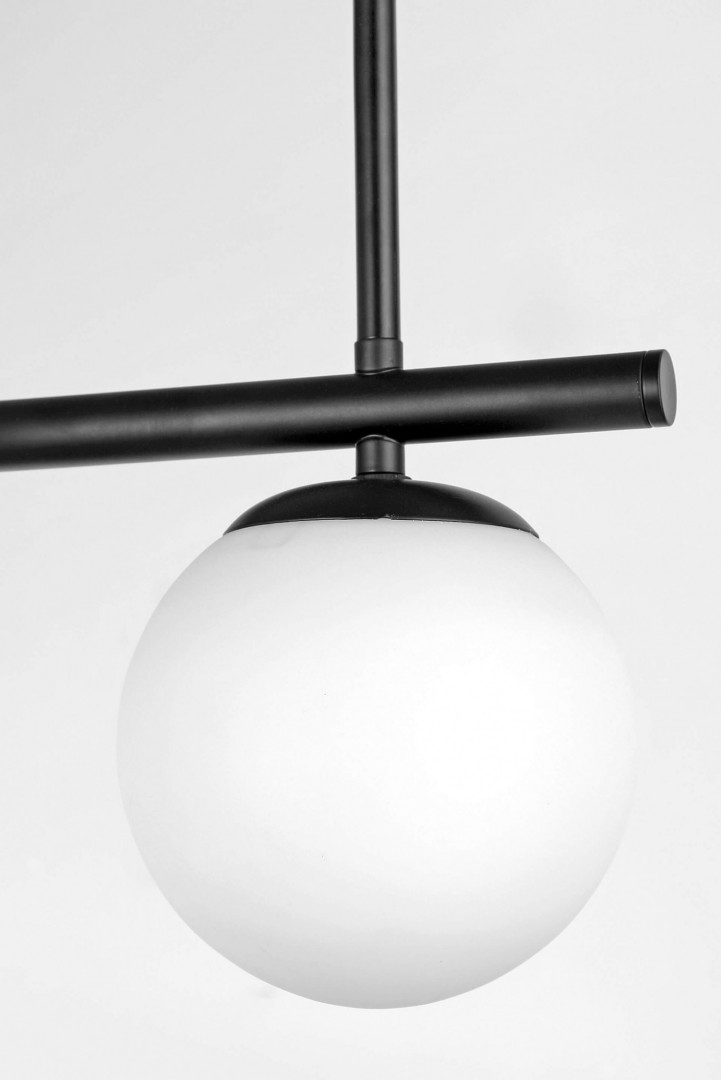 Detal lampy wiszącej z czarną konstrukcją i matowym kloszem w stylu nowoczesnym – zbliżenie na mleczno - biały klosz