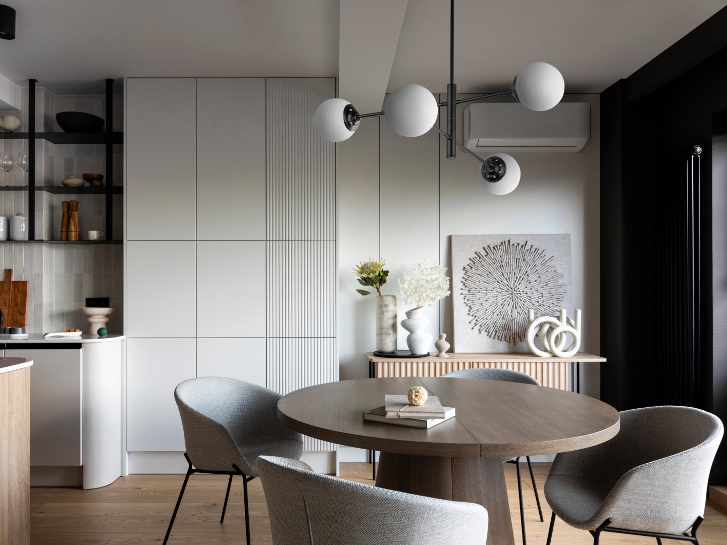 Nowoczesna czarna lampa wisząca z białymi kulami w eleganckiej jadalni w stylu minimalistycznym