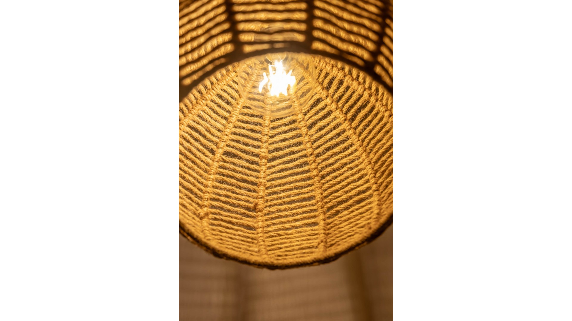 Sznurkowy klosz lampy wiszącej tworzący subtelne cienie w stylu boho