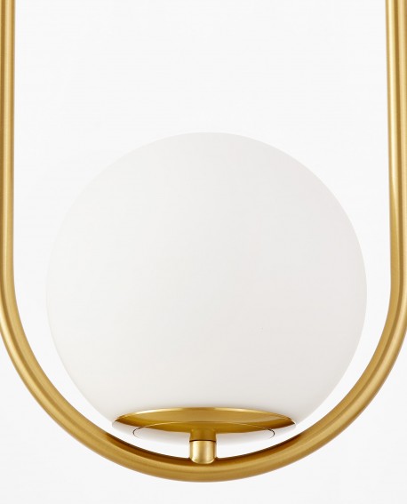 Zbliżenie na okrągły biały klosz i szczotkowane złoto w nowoczesnej lampie