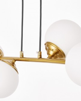 Zbliżenie na złoty element lampy wiszącej w stylu nowoczesnym z białymi kulami