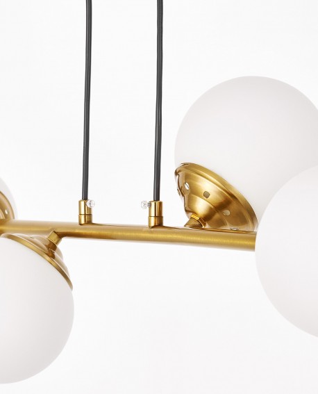 Zbliżenie na złoty element lampy wiszącej w stylu nowoczesnym z białymi kulami