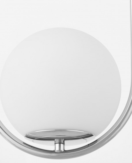 Zbliżenie na biały szklany klosz lampy wiszącej z chromowanym detalem