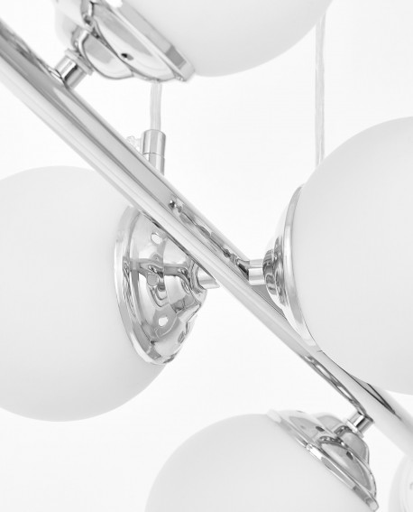 Zbliżony detal chromowanej lampy wiszącej z białymi szklanymi kloszami