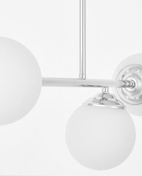 zbliżenie białego szklanego klosza w lampie wiszącej na srebrnym ramieniu