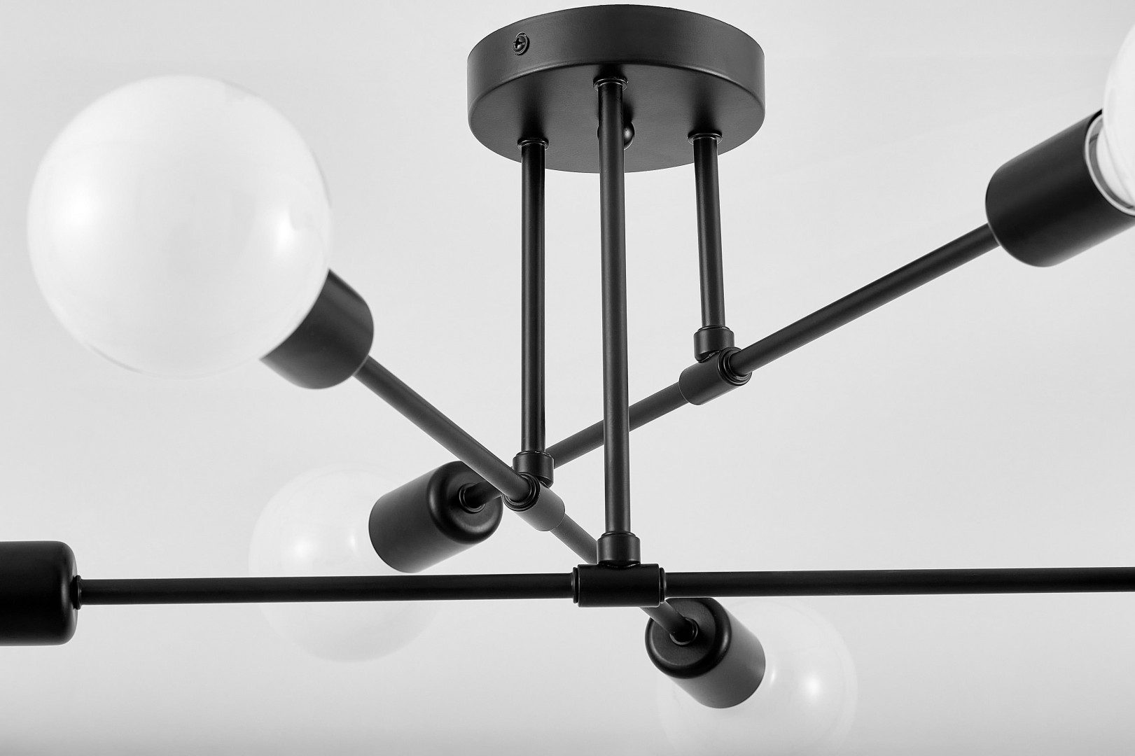  Czarna lampa sufitowa Nova od Lampit z metalową podstawą i mlecznymi kulami pokazana w detalach z nowoczesnym wykończeniem
