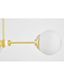 Zbliżenie na złote wykończenie mocowania lampy z białym kloszem, podkreślające elegancki detal