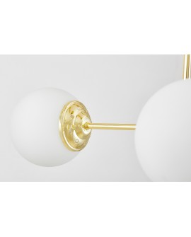  Zbliżenie na złote mocowanie klosza lampy z detalami wykończenia oraz metalową konstrukcją.