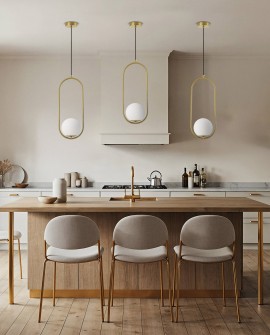 Lampa wisząca Lampit w kolorze szczotkowanego złota zamontowana nad wyspą w kuchni