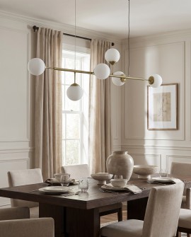  Designerska lampa FINO w złocie o linearnej formie zawieszona nad stołem w luksusowej kuchni modern