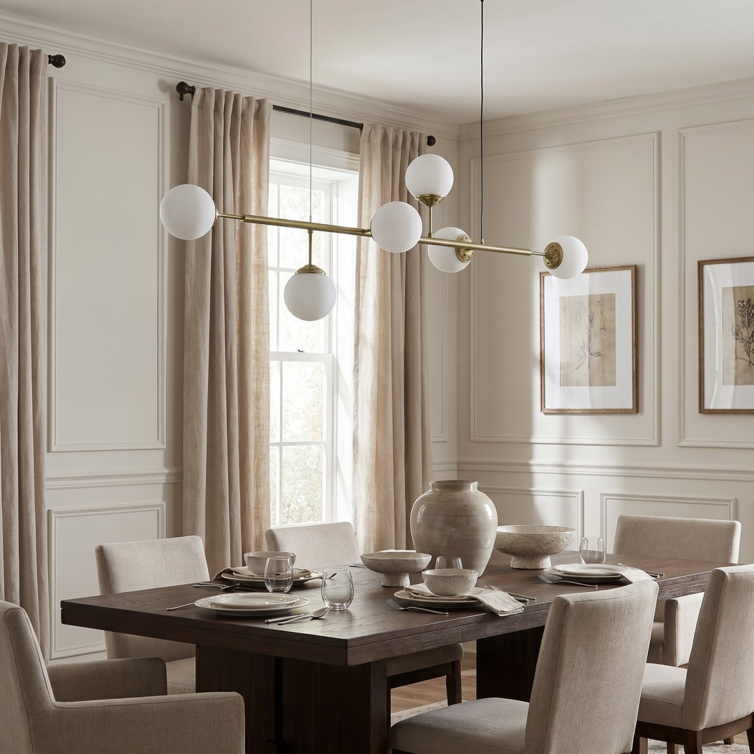  Designerska lampa FINO w złocie o linearnej formie zawieszona nad stołem w luksusowej kuchni modern