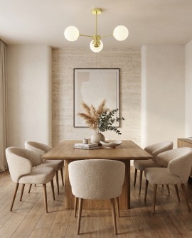 Lampa sufitowa z trzema białymi okrągłymi kloszami na złotej ramie w nowoczesnym salonie nad stołem
