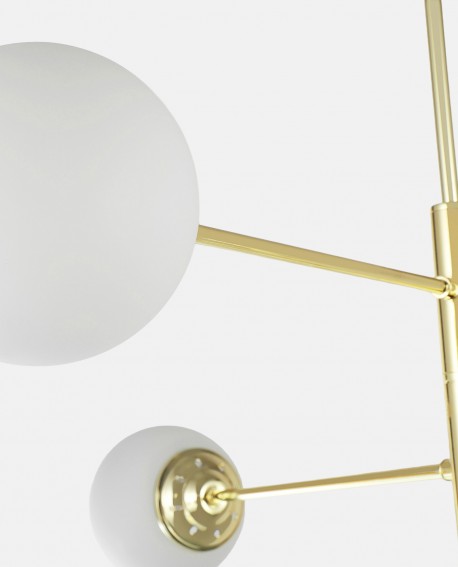 Nowoczesna lampa wisząca z sześcioma mlecznymi kloszami na złotych ramionach, w stylu geometrycznym.