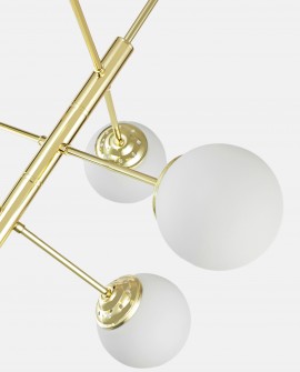 Zbliżenie złotej lampy wiszącej z białymi kulistymi kloszami na jasnym tle