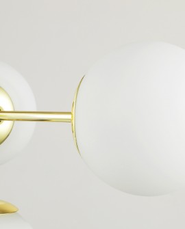 Detal złotej lampy wiszącej z matowym kloszem, nowoczesny design do salonu