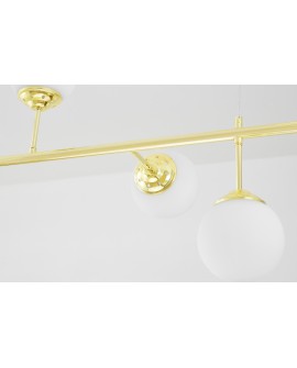 Detal konstrukcji lampy glamour ze złotym ramieniem i białą kulą z matowego szkła.