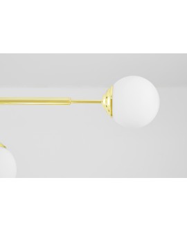 Zbliżenie na złoty stelaż lampy z okrągłym, matowym kloszem w stylu glamur