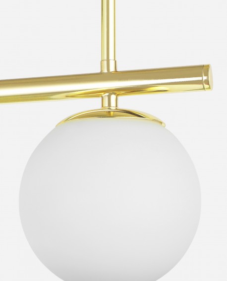 Detal lampy wiszącej ze złotą konstrukcją i matowym kloszem w stylu nowoczesnym zbliżenie na mleczno biały klos