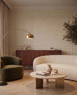 Mosiężna lampa stojąca do czytania przy okrągłym stoliku i sofie w jasnym salonie