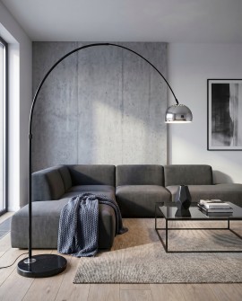 Stojąca lampa łukowa z metalowym chromowanym kloszem obok narożnika