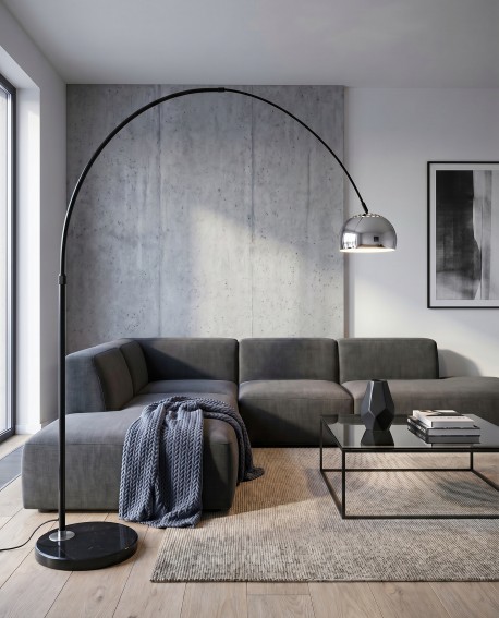 Stojąca lampa łukowa z metalowym chromowanym kloszem obok narożnika