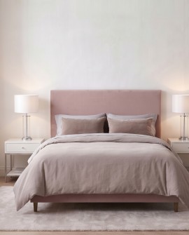 Lampa w stylu glamour ustawiona na białym stoliku nocnym po lewej stronie łóżka