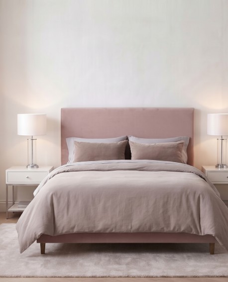 Lampa w stylu glamour ustawiona na białym stoliku nocnym po lewej stronie łóżka