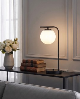 Nowoczesna lampa stołowa TESO z białą kulą na czarnym stoliku w salonie